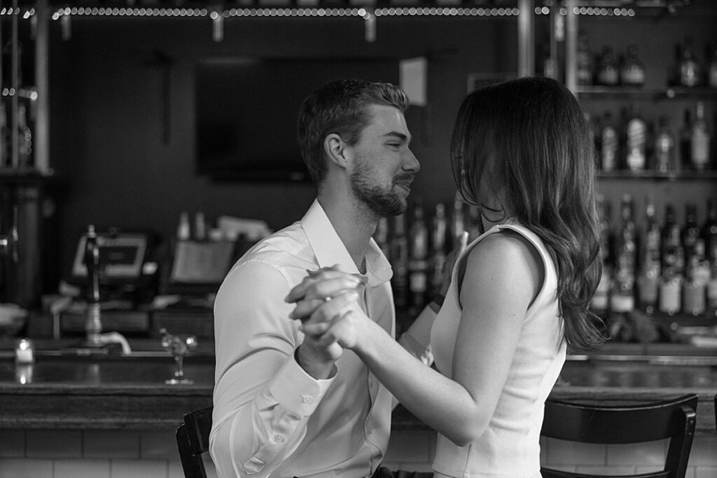 Couple holding hands at a bar during their engagement photos in Philadelphia by Kristy Hoadley