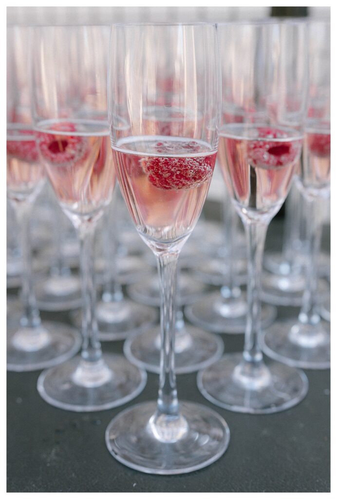 Champagne glasses with raspberry at Cescaphe Waterworks wedding reception
