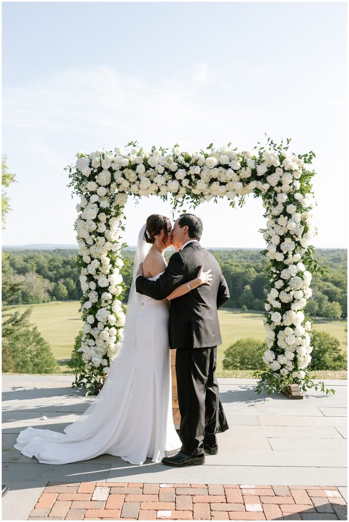 First kiss under floral arbor by Jardinere a New Jersey wedding floral designer